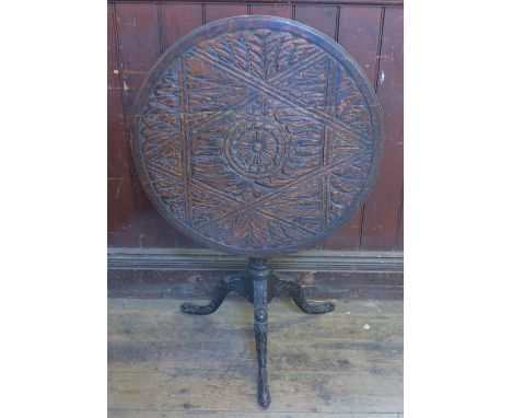 A 19th century oak circular occasional table, raised on a tripod base, the whole being heavily carved, diameter 29ins