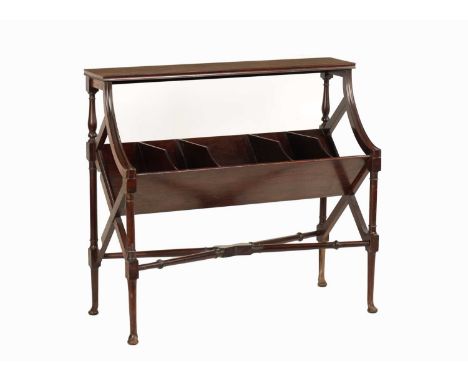 AN EDWARDIAN MAHOGANY LIBRARY BOOK TROUGH of deep angled form below a shelf top; raised on ring-turned legs joined by a turne