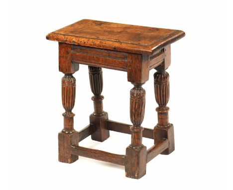 A CHARLES II WALNUT AND OAK JOINT STOOL with moulded rectangular walnut top above a recessed carved oak frieze, of pegged con