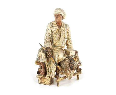 AN EARLY 20TH CENTURY COLD PAINTED SPELTER SCULPTURE depicting an Arabian man with a pipe seated on a bench - signed on rever