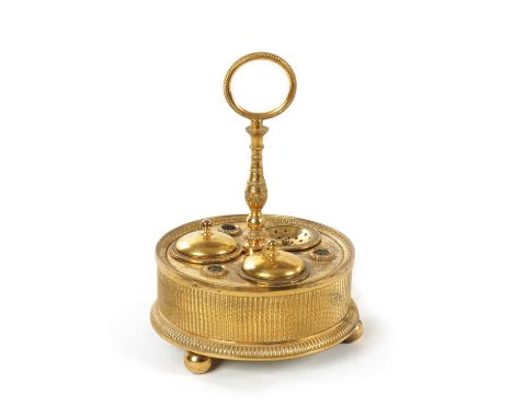 A GOOD EARLY 19TH CENTURY FRENCH ORMOLU PEN AND INK DESK STAND of circular form with turned centre ring carrying handle, fitt