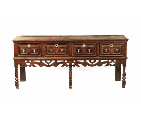 A WILLIAM AND MARY OAK MOULDED FRONT DRESSER BASE with plank top above overall three moulded frieze drawers fitted pear drop 