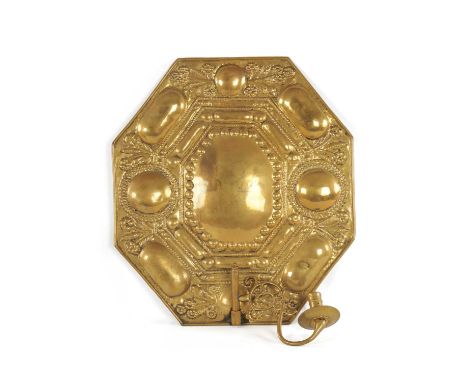 A 17TH CENTURY PRESSED BRASS CONTINENTAL HANGING WALL LIGHT the octagonal panelled back decorated with floral sprays; fitted 