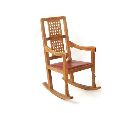 A ROBERT 'MOUSEMAN' THOMPSON ADZED OAK ROCKING CHAIR of dowelled construction with double panel woven strapwork back-shaped a