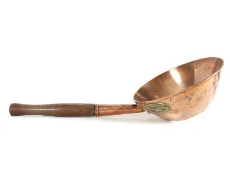 AN 19TH CENTURY COPPER SCOOP OF UNUSUALLY LARGE SIZE labelled R W ANDREWS &amp; Co. London with riveted shank and shorted tur