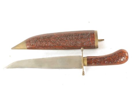 AN EARLY 20TH CENTURY INDIAN BOWIE KNIFE with single-edged steel blade and brass guard on a leaf carved wooden handle, matchi