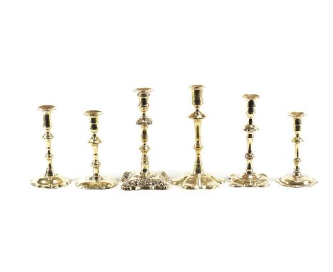 A SELECTION OF PETAL BASED SEAMED BRASS CANDLESTICKS AND A RARE CAST BRASS ROCOCO STYLE CANDLESTICK all period early 18th cen