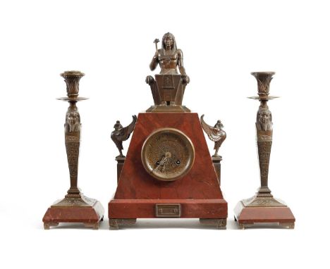 A LATE 19TH CENTURY EGYPTIAN STYLE FRENCH BRONZE AND ROUGE MARBLE CLOCK GARNITURE the pyramid shaped case surmounted by a sea