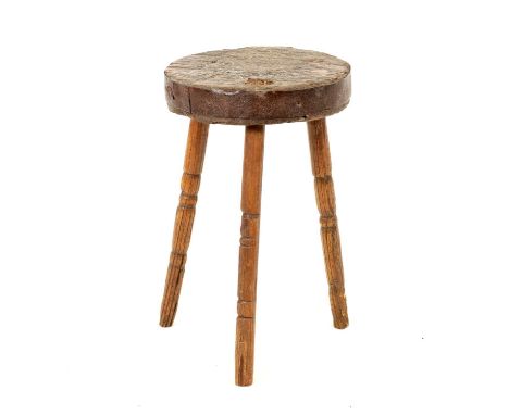 18TH CENTURY PRIMITIVE ELM STOOL with iron-bound circular top raised on a turned splayed tripod base.47cm high, 29cm Diameter