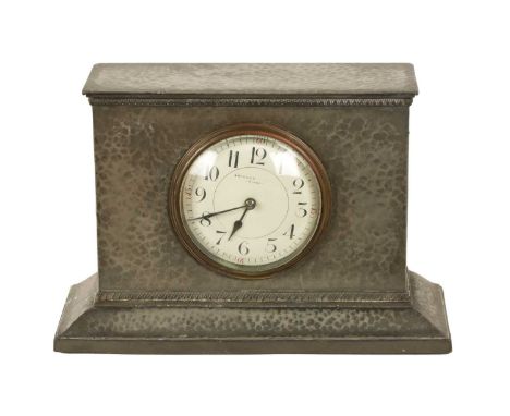 LIBERTY &amp; CO. AN ARTS AND CRAFTS ENGLISH PEWTER MANTEL CLOCK the planished design with moulded base enclosing an enamel d