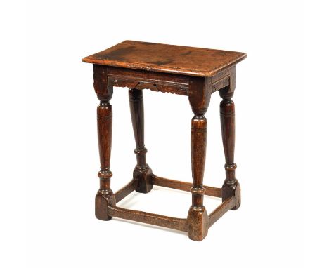 A 17TH CENTURY OAK JOINT STOOL the moulded rectangular top above a shaped, moulded and pierced carved frieze; supported over 