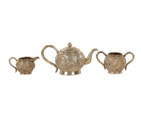 A LATE 19TH CENTURY CHINESE SILVER MINIATURE THREE PIECE TEA SERVICE comprising teapot, milk jug and sugar pot with embossed 