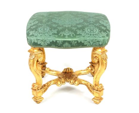 AN 18TH CENTURY CARVED GILTWOOD STOOL WITH PERIOD SILK DAMASK SEAT raised on leaf-carved scrolled legs joined by an X-shaped 