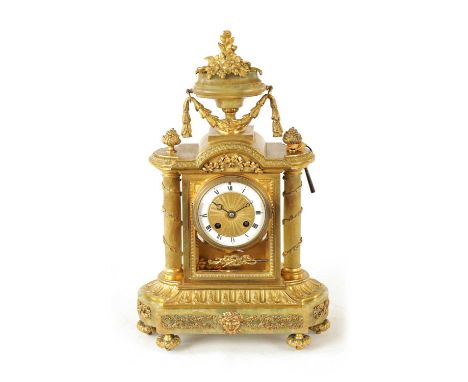 A LATE 19TH CENTURY FRENCH ORMOLU AND ONYX MANTEL CLOCK with large urn and swag finial above glazed case with turned onyx pil