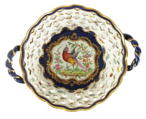 A 19TH CENTURY FIRST PERIOD WORCESTER TYPE TWO-HANDLED LATTICEWORK BASKET decorated in blue and gilt with an exotic bird encl