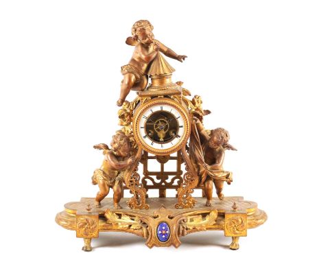 A LATE 19TH CENTURY FRENCH GILT METAL FIGURAL MANTEL CLOCK with three winged cherubs playing amongst garlands on a shaped pli