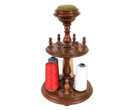 A 19TH CENTURY TURNED MAHOGANY BOBBIN STAND of two graduated tiers on a baluster turned stem with pin cushion top and turned 