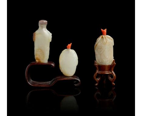  GROUP OF THREE PALE CELADON JADE SNUFF BOTTLES QING DYNASTY, 19TH CENTURY 清 青白玉雕瓜瓞綿綿 及 蕉葉舖首紋鼻烟壺 帶木座（共三件）comprising: an oblon