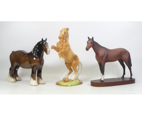 Three Ceramic Horses to include Beswick Palomino Rearing 1014 a/f, Royal Doulton Brown Horse on Wooden Base and  and a Beswic