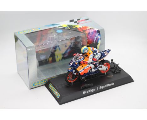 Scalextric - A boxed 2004 Moto GP Repsol Honda ridden by Max Biaggi # C6022 The model appears Mint in a Very Good perspex dis