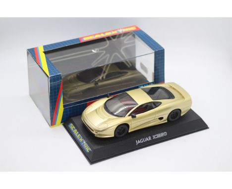 Scalextric - A boxed Jaguar XJ220 in gold with working lights # C2083. The car appears in Mint condition in a Very Good persp