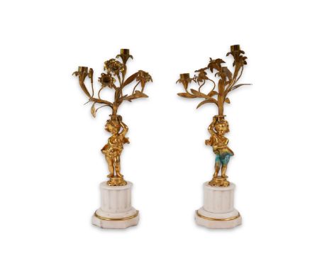 A pair of Victorian style ormolu and white marble candelabra, with flower stem three light branches, putto columns and fluted