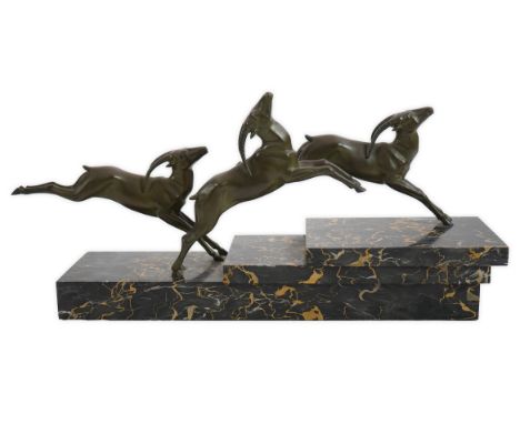 G. Daverny, a French Art Deco patinated bronze group of four running gazelles, on a stepped variegated marble base, signed on