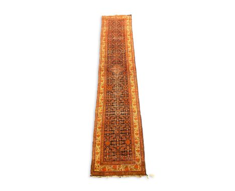 A Malayer runner, with central field of geometric motifs on a black ground, 495 x 102cm PLEASE NOTE:- Prospective buyers are 