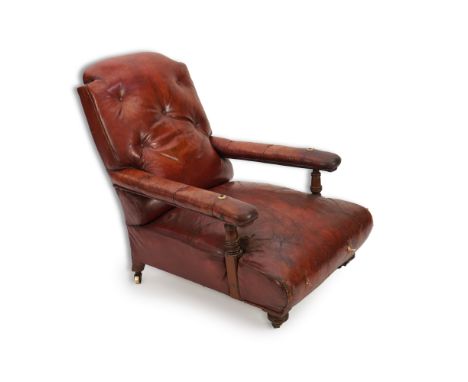 A Victorian mahogany club reading chair, upholstered in original brick red leather, on ring turned legs, fitted brass castors
