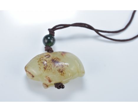 A Chinese carved celadon and brown jade animal pendant. 4.5cm length
