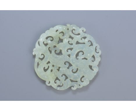 A Chinese carved jade pendant depicting a dragon and phoenix. 6cm diameter