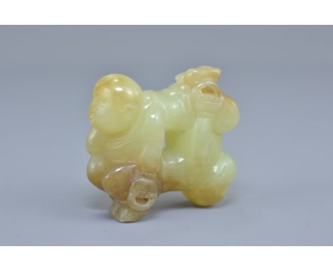 A Chinese celadon and brown jade carving of two boys. 5cm x 5cm