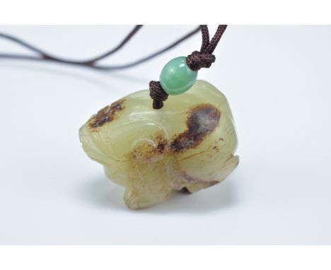 A Chinese carved celadon and brown jade animal pendant. 3.5cm length