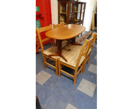A Set of Four Rush Seated Back Dining Chairs and an Oval Vintage Coffee Table