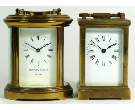 A brass 8 day carriage clock of oval form, retailed by Matthew Norman of London, together with an unnamed example. (2) 13cm t