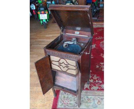 A Melodist freestanding record player, hinged doors open to reveal a speaker and lower shelf, on tapered legs 