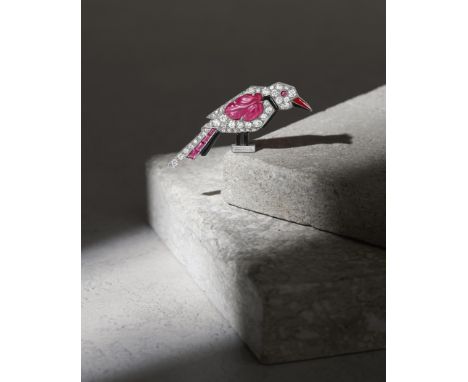 CARTIER: RUBY, DIAMOND AND ENAMEL BROOCH, CIRCA 1925Modelled as a woodpecker resting on a baguette-cut diamond perch, pavé-se