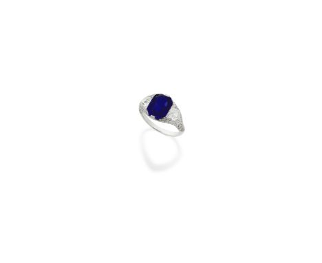 SAPPHIRE AND DIAMOND RING, CIRCA 1925The step-cut sapphire, weighing 5.01 carats, set between old brilliant and single-cut di