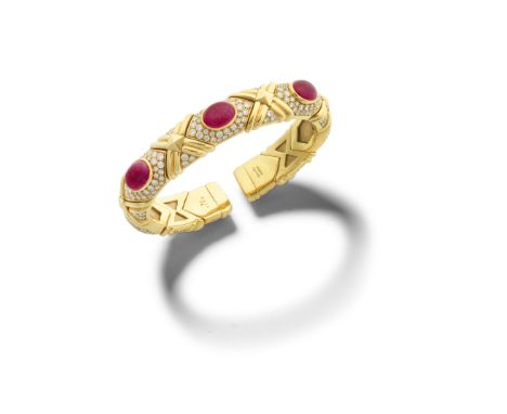 BULGARI: RUBY AND DIAMOND BANGLESet to the front with three oval cabochon rubies, the sprung bangle composed of lozenge-shape