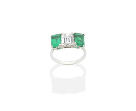 EMERALD AND DIAMOND RINGThe step-cut diamond weighing 2.14 carats, between similarly-cut  emeralds, weighing 1.55 carats and 