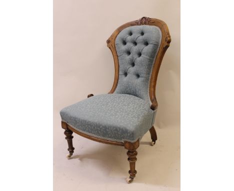 19th Century walnut balloon back and button upholstered low seat nursing chair on turned tapering and reeded supports, with o