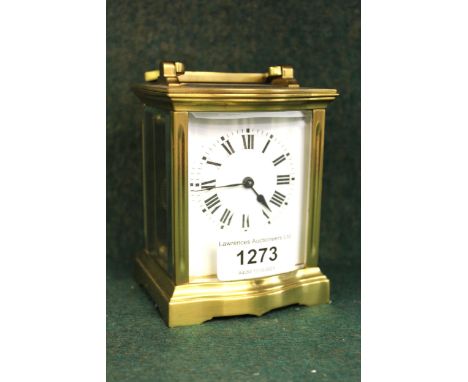 Small brass cased carriage clock with enamel dial and Roman numerals, in a bow fronted case, 10cm high excluding the loop han