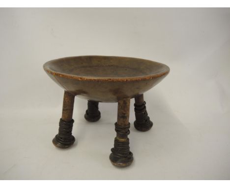 19th Century tribal carved hardwood dug-out stool / bowl on tapering supports bound with iron rings, 30cm diameter (at fault)