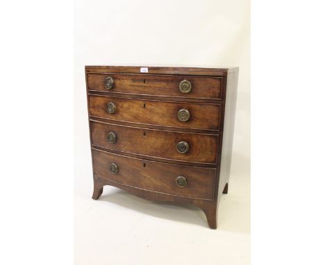 Small George III mahogany crossbanded and line inlaid bow front chest of four graduated drawers, with circular brass ring han