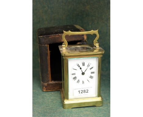 Small brass cased carriage clock having original outer leather covered case 