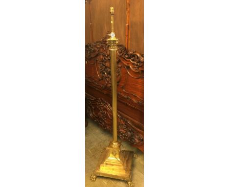A heavy brass Corinthian column standard lamp with square stepped base and lion paw feet