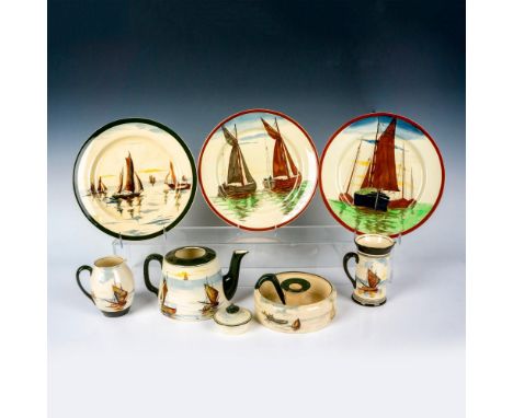 A seriesware grouping, featuring 3 plates, a candle holder dish, tall creamer, small pitcher, and lidded teapot. All adorned 
