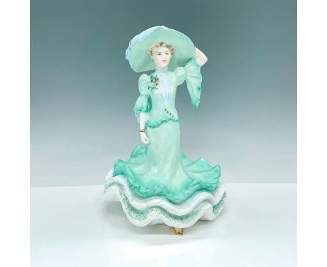 This stunning porcelain figure depicts a lady elegantly dressed in a light green gown with exquisite low ruffles and a comple