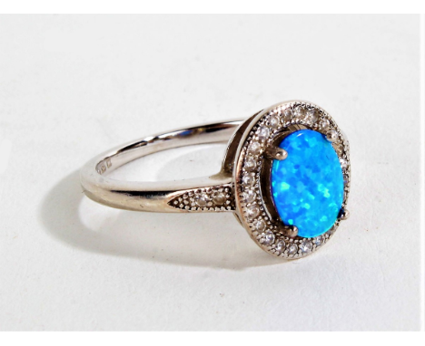 Silver and opal ring, with an oval opal with an outer ring of paste stones, ring size O gross weight 2.4 grams&nbsp;