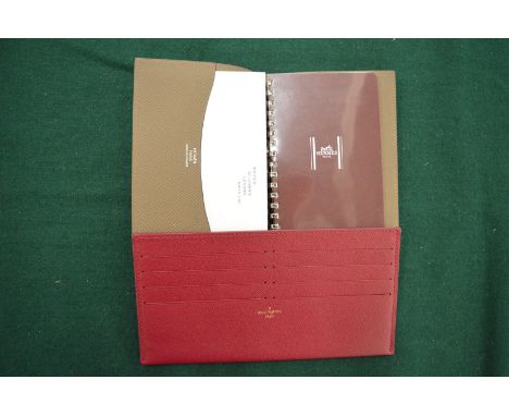 A Hermes leather cased note pad and a Louis Vuitton red leather credit card holder.